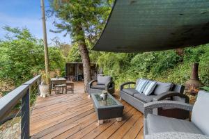 une terrasse en bois avec des canapés et des chaises. dans l'établissement Cottage dAmour Waterfront, à Spencer
