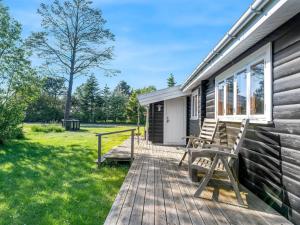 a deck with two benches on the side of a house at Holiday Home Bengta - 500m from the sea by Interhome in Gedser