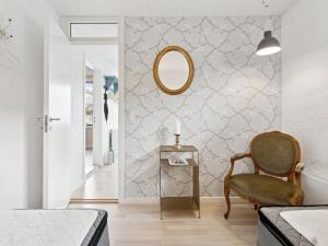 Un dormitorio con un espejo y una silla. en Apartment Elsabeth - 50m from the sea by Interhome, en Allinge