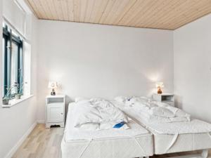Un dormitorio blanco con una cama y un techo de madera. en Apartment Elsabeth - 50m from the sea by Interhome, en Allinge