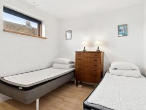 1 dormitorio con 2 camas, vestidor y ventana en Apartment Elsabeth - 50m from the sea by Interhome, en Allinge