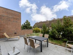 a patio with a black table and chairs at Apartment Øgoti - 500m from the sea by Interhome in Sønderby