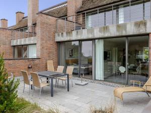 a patio with a table and chairs in front of a building at Apartment Øgoti - 500m from the sea by Interhome in Sønderby