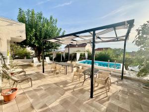 a patio with a table and chairs and a pool at Summer app Pool Spa jacuzzi 2 in Makarska
