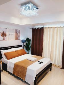 a bedroom with a large bed and a chandelier at Boracay Tower by Janet in Manila +13 photos