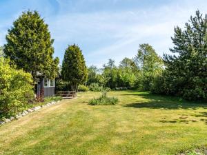 an empty yard with trees and a house at Holiday Home Meindor - 240m to the fjord by Interhome in Storvorde