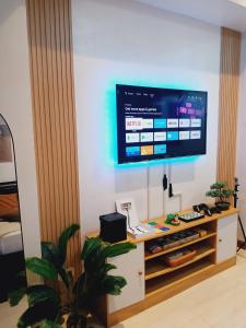 a living room with a television on a wall at Boracay Tower by Janet in Manila