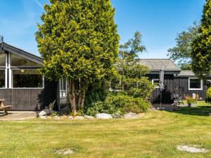 a house with a tree in front of a yard at Holiday Home Meindor - 240m to the fjord by Interhome in Storvorde