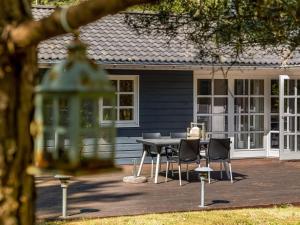 a patio with a table and chairs in front of a house at Holiday Home Eikka - 1km from the sea by Interhome in Læsø +21 photos