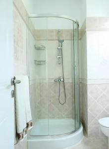 a shower with a glass door in a bathroom at Haraki Beach Mediterranean Retreat in Haraki