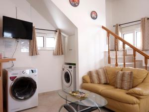 a living room with a couch and a washing machine at Haraki Beach Mediterranean Retreat in Haraki