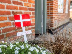 a red and white sign in front of a brick building at Holiday Home Deik - 25km from the sea by Interhome in Højer