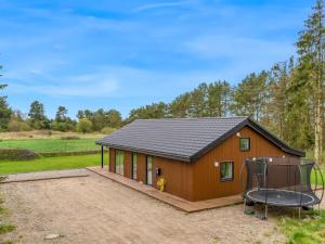 a small house with a black roof at Holiday Home Herwarth - 2-3km from the sea by Interhome in Hals