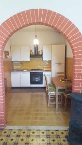 a kitchen with an archway with a table and appliances at L'Angolo con vista a Bajardo in Berzi
