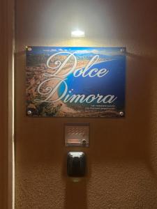 a sign on the wall of a door with a bottle of oreo at Dolce Dimora in Milazzo
