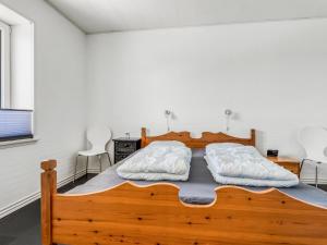 1 Schlafzimmer mit einem Holzbett und 2 Stühlen in der Unterkunft Holiday Home Kora - 2km from the sea by Interhome in Læsø