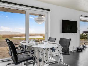 a dining room with a table and chairs and a large window at Holiday Home Kora - 2km from the sea by Interhome in Læsø