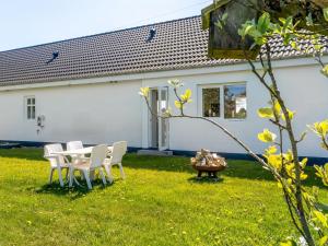 a table and chairs in the yard of a house at Holiday Home Kora - 2km from the sea by Interhome in Læsø