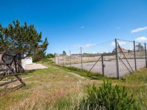 a fence in front of a road with a gate at Holiday Home Mimi - 900m from the sea by Interhome in Blokhus