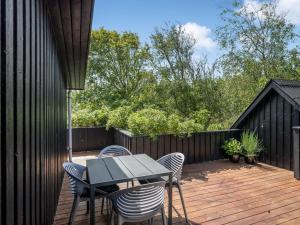 a patio with a table and chairs on a wooden deck at Holiday Home Fatima - 1km from the sea by Interhome in Fanø