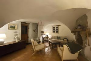 a living room with a couch and a table and chairs at Maison en Provence ancien moulin in Entrepierres