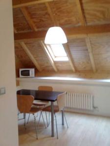 a dining room with a table and chairs and a light at Casa de los Beneficiados in Roncesvalles +12 photos