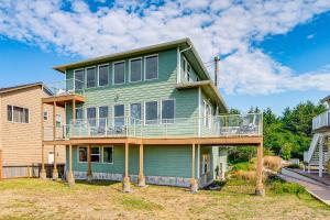 a green house with a balcony on top of it at Copalis Beach Family Home Close to Sites and Nature in Copalis Beach