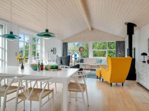 een keuken en woonkamer met een witte tafel en stoelen bij Holiday Home Toska - 3km from the sea by Interhome in Blokhus