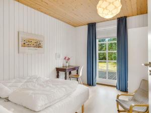een slaapkamer met een bed, een tafel en een raam bij Holiday Home Toska - 3km from the sea by Interhome in Blokhus