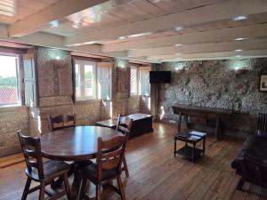 a room with a table and chairs and a piano at Casa dos Bernardos in Terras de Bouro