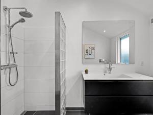 a white bathroom with a sink and a shower at Holiday Home Carlie - 250m to the fjord by Interhome in Esbjerg +22 photos