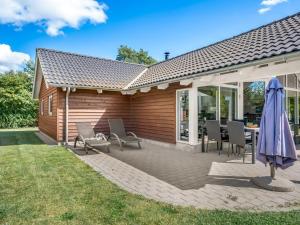 a patio with a table and chairs and an umbrella at Holiday Home Annielle - 500m from the sea by Interhome in Rødby