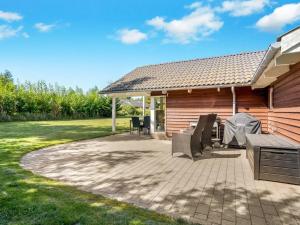 a patio with tables and chairs and a house at Holiday Home Annielle - 500m from the sea by Interhome in Rødby