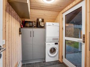 a small kitchen with a washing machine and a washer at Holiday Home Annielle - 500m from the sea by Interhome in Rødby +16 photos