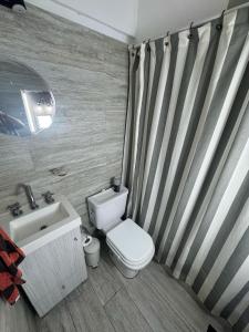 a bathroom with a toilet and a sink at Sunset Loft in Pinamar +8 photos