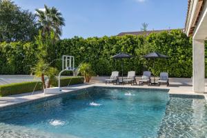 une piscine avec chaises et parasols dans une cour dans l'établissement Chandler Scorpio, à Serape