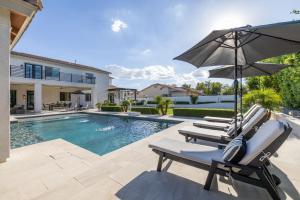 une piscine avec deux chaises longues et un parasol dans l'établissement Chandler Scorpio, à Serape