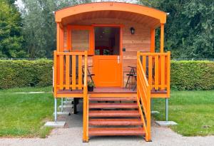 ゲッティンゲンにあるFerienhauspark im Freibad Brauweg - Rolling Lodgesの庭に階段があるオレンジ色の離れ