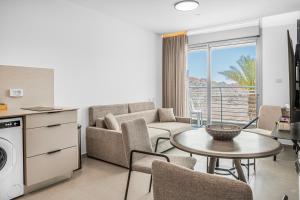 a living room with a couch and a table at Yalarent Amazing apartments U360 Complex Eilat in Eilat