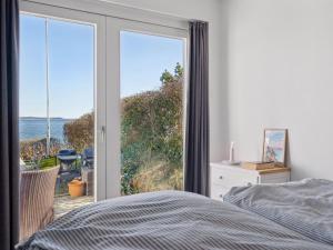 une chambre avec un lit et une vue sur l'océan dans l'établissement Holiday Home Solbritt - 30m from the sea by Interhome, à Broager