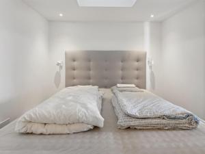 une chambre blanche avec un grand lit avec des draps et des oreillers blancs dans l'établissement Holiday Home Solbritt - 30m from the sea by Interhome, à Broager