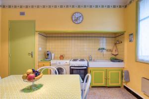une cuisine avec une table avec un bol de fruits dessus dans l'établissement La Coustouline, à Lacoste 22 autres photos