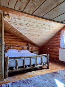 a bed in a room with a wooden ceiling at Artem Chalet in Ciocanu