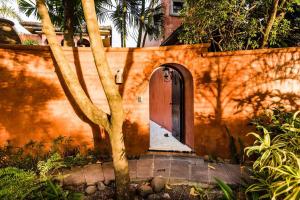 un edificio naranja con una puerta y un árbol en Luxury Villa, Near The Beach With A Private Pool, en Tamarindo
