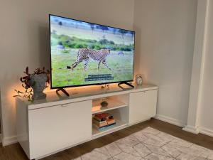 a flat screen tv sitting on a white entertainment center at Cozy Guest Suite Walk to Ocean & Shops in West Vancouver