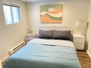 a bedroom with a bed and a painting on the wall at Cozy Guest Suite Walk to Ocean & Shops in West Vancouver