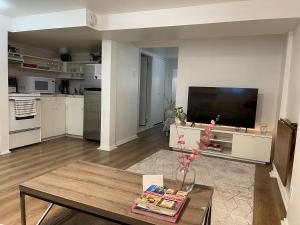 a living room with a table and a tv at Cozy Guest Suite Walk to Ocean & Shops in West Vancouver