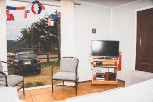 ChacurraにあるCabañas Entremarのリビングルーム(テレビ、椅子2脚付)