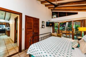 a bedroom with a bed and a living room at Hidden Oasis Across The Street From The Beach in Tamarindo +17 photos
