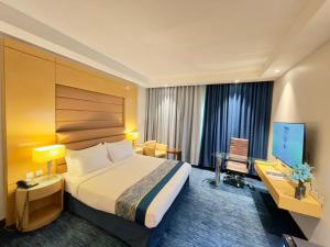 a hotel room with a bed and a desk and a television at Blue Rose Garden Hotel فندق بلو روز جاردن العليا in Riyadh